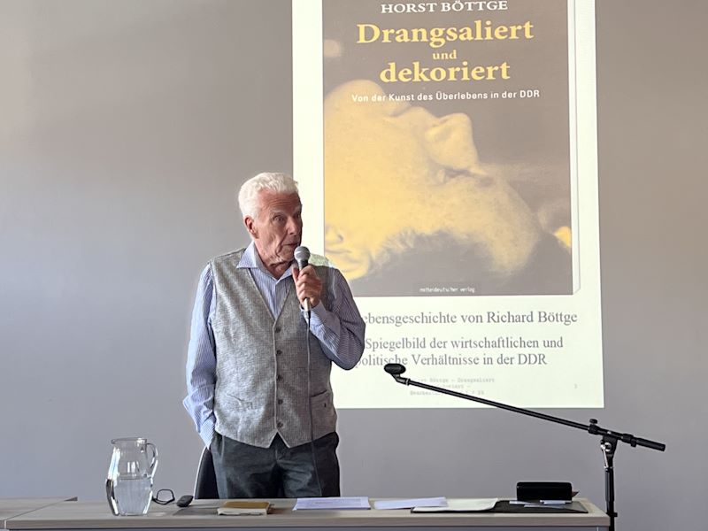 Herr Böttge mit Mikrofon am Rednerpult