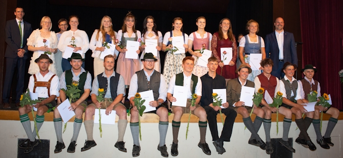 Staatspreisträger*innen der Berufsschule im Sommer 2023 auf der Bühne sitzend