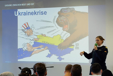 Junge Frau vor Leinwand im Klassenraum