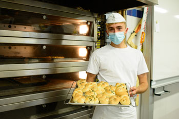 Schüler mit Backwerk in der Backstube